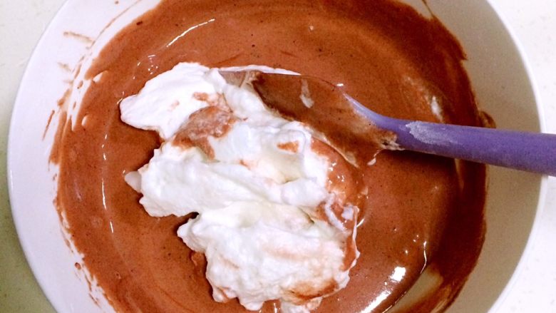 红丝绒奶油蛋糕杯,把打发好的蛋白糊分三次加入红曲蛋黄糊中进行翻拌均匀。