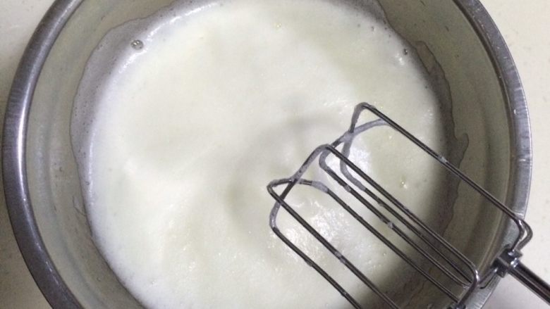 红丝绒奶油蛋糕杯,慢慢的转中速把蛋白打至细腻时，加入1/3细砂糖继续搅打。