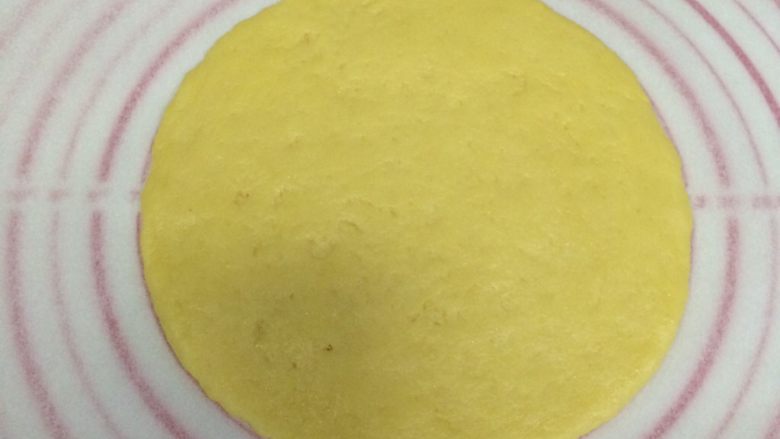 红豆葡萄干松饼,将面团分成两份，放一张油纸，取一份面团在油纸上擀成圆形的饼状。