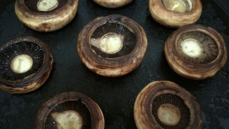 黄油煎口蘑,再将口蘑翻过来煎2到3分钟，直到口蘑的小盏碗里出现一些汁水。