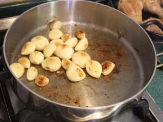 大蒜炖鸡,倒掉多余的油脂，将大蒜加入锅中，煎至表面微金棕色。