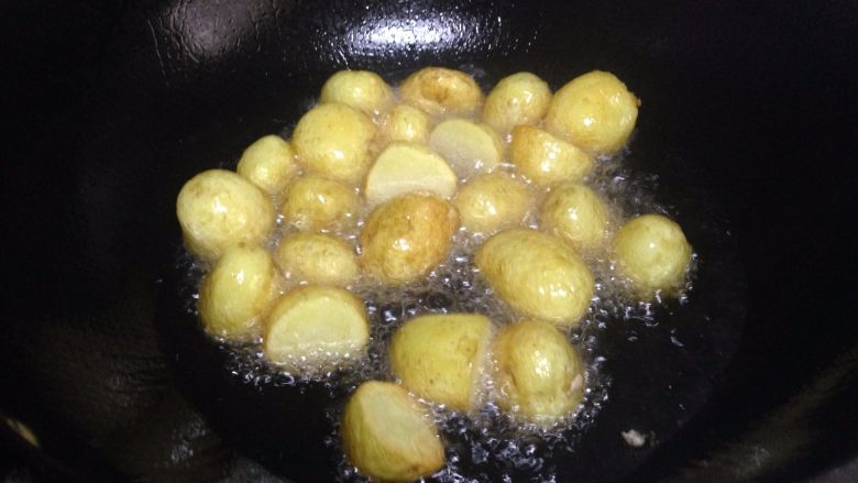小土豆炖肉,锅内加适量油中火倒入土豆炸制表面金黄时捞出
