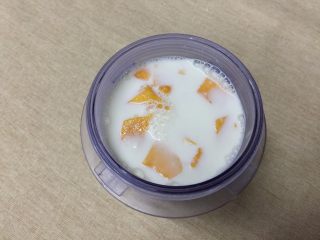 奶昔与沙拉CP，夏日冰凉组合,把牛奶、芒果和适量白砂糖放进料理杯内