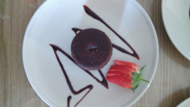 巧克力熔岩蛋糕,脱模，配上新鲜水果，淋上巧克力酱进行装饰摆盘