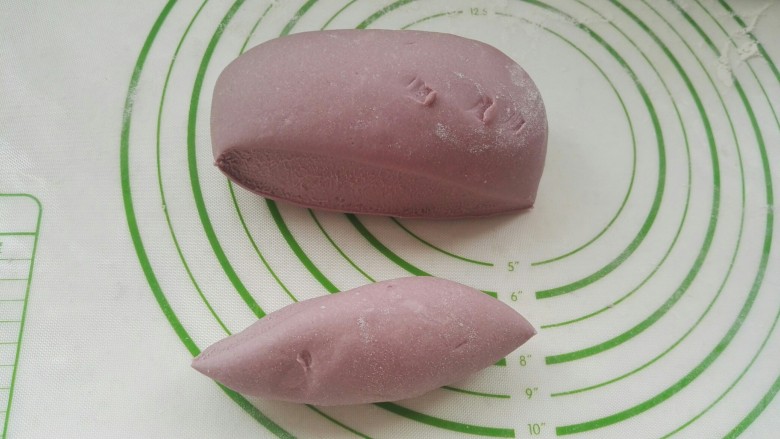 紫薯皮鸭蛋韭菜粉条馅素饺子(一饺两吃),用刮刀切下一块(硅胶垫怕刀割，所以用刮刀分剂)。