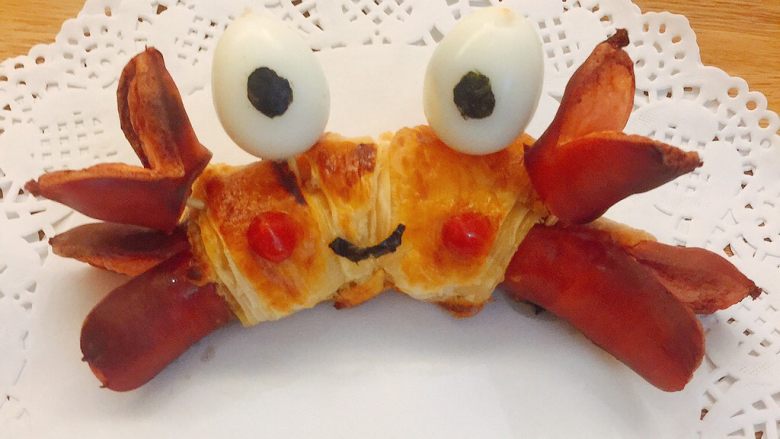炒鸡萌的螃蟹热狗包,插上螃蟹的眼睛和蟹钳，贴上螃蟹的嘴，用番茄酱装饰红脸蛋；