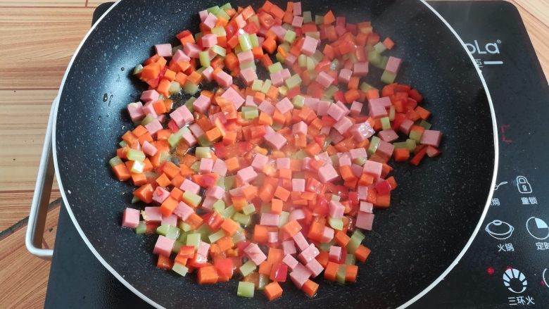 菠萝蛋炒饭,锅里放入少量油翻炒一下蔬菜丁和火腿肠丁