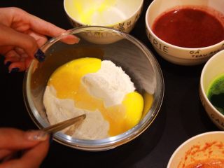 多色玫瑰花饺子,蛋黄去掉蛋清部分，直接倒入装好面粉的碗里，反复揉捏至成团，达到细腻有柔性，这样饺子皮才有韧劲