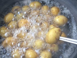 香辣香草小土豆,土豆煮至用筷子能轻易扎进去的程度，出锅晾凉后剥去土豆皮