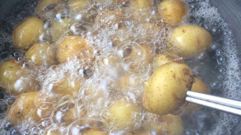 香辣香草小土豆,土豆煮至用筷子能轻易扎进去的程度，出锅晾凉后剥去土豆皮