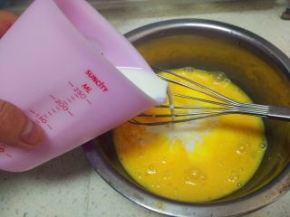 原味蛋挞布丁,把牛奶倒入鸡蛋液里搅拌。

