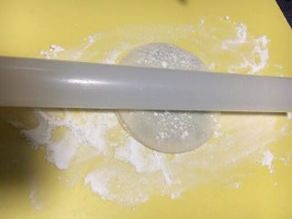 饺子皮香葱饼,表面稍微撒点干粉，用擀面杖向四周擀开