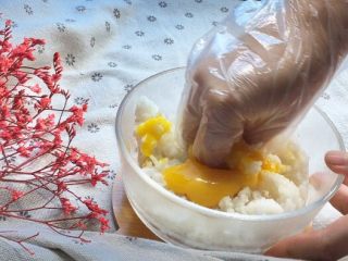 福袋黄金饭,带上手套抓匀，确保每颗米饭都裹上蛋黄液，这样炒出来的米饭颗颗金黄哦