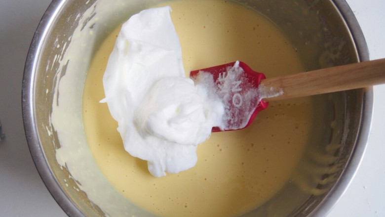 爱心酸奶蛋糕卷,取三分之一蛋白霜放入蛋黄糊中，翻拌均匀