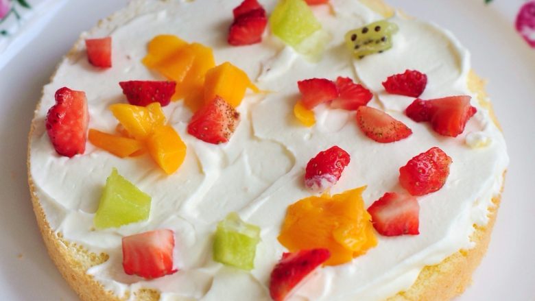 鲜果裸蛋糕,取一片蛋糕片垫底，先抹一层奶油，均匀撒上水果粒。 