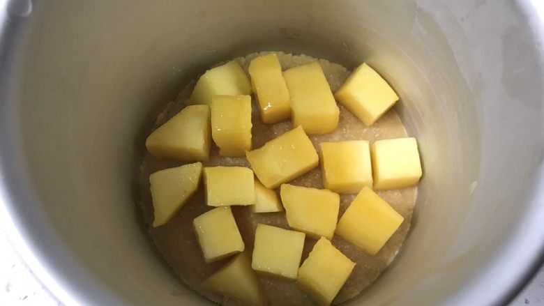 夏日芒果慕斯,取出冷冻好的饼干底，放入适量芒果块。