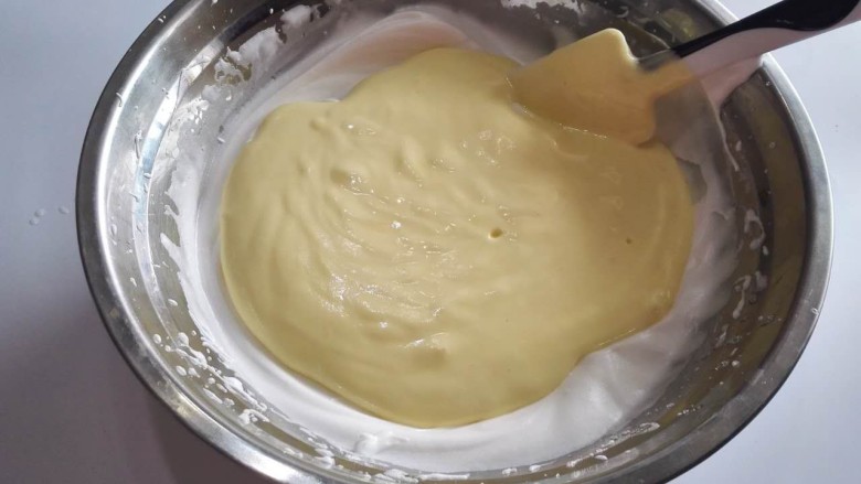 四寸加高戚风蛋糕,将蛋黄糊倒入到剩下的蛋白里面。