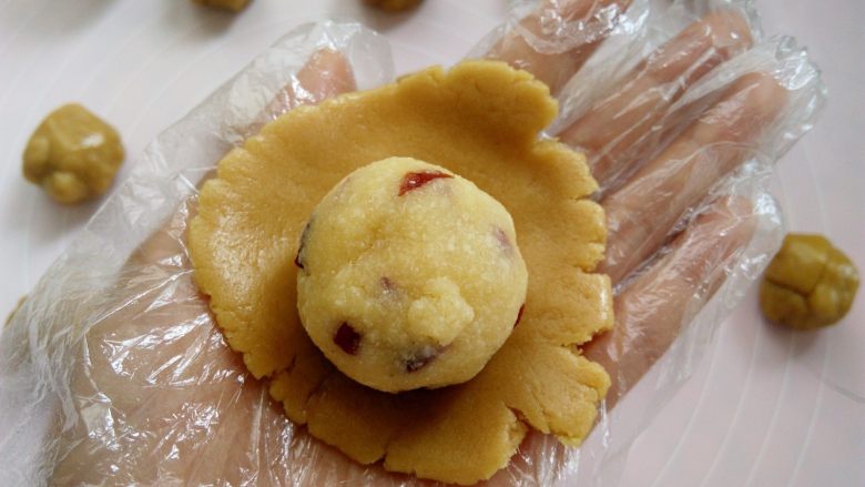 椰蓉蔓越莓月饼, 戴上一次性手套，取其中一个面团用2个掌心的摩擦力按扁，放上椰蓉蔓越莓馅