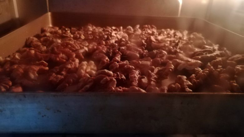 核桃蔓越莓牛轧糖,核桃去壳后放入烤箱中层200度烤5分钟