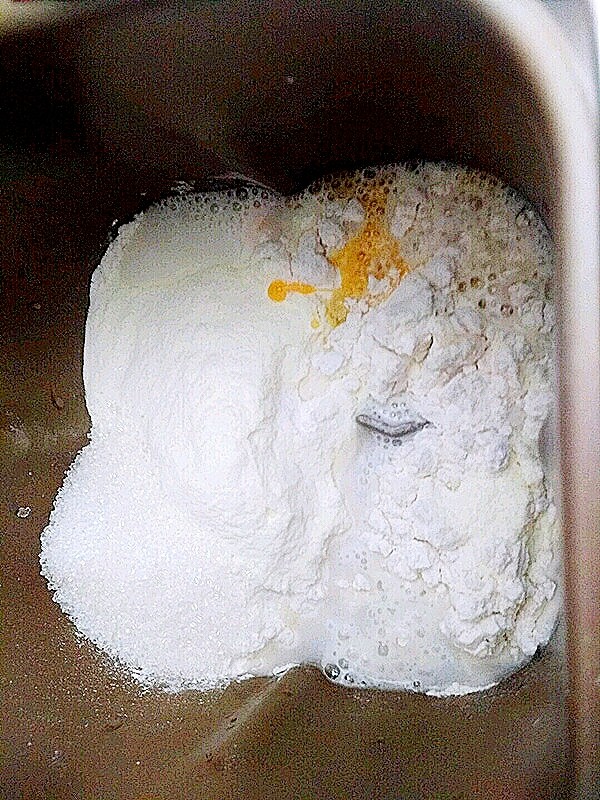  小红豆包,把面粉放入面包桶里，最好把面包粉过筛。然后放入酵母和盐，酵母和盐最好放在面包桶的两个角上。