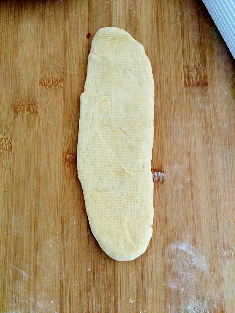   小红豆包,把长条擀成长舌状，把红豆沙涂抹后，从上往下卷起来，卷的时侯两边要收紧一点。