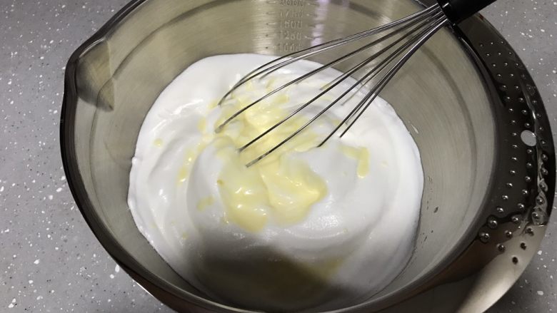 柠檬魔法蛋糕,蛋白霜倒入蛋黄糊。手动打蛋器用捞取的手法翻拌几下，不用翻拌太多次，表面看不到大块蛋白即可。