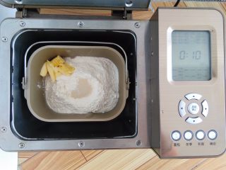 香軟肉松牛奶排包,按照先液體再粉末的順序依次放入主配方中的所有材料，酵母放面粉上，軟化好的黃油放一側角落，啟動面包機的和面程序，和面30分鐘。這次的配方用的面