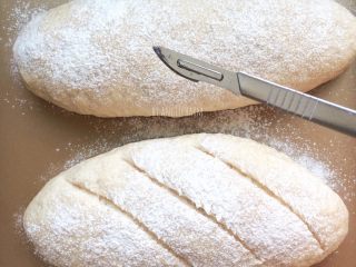 黑麦面包（海绵酵头）,预热烤箱180度。面团上薄薄的筛一层高粉，割包。