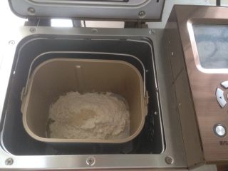 香肠玉米白面包,加入奶粉和面粉，在面粉顶端加入酵母，将面包桶放入到面包机里