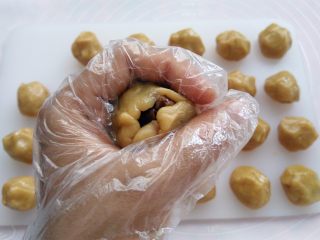核桃枣泥月饼,手心合起来，用虎口把面团慢慢收圆，皮厚的地方可以推到皮薄的地方，尽量推的均匀一点