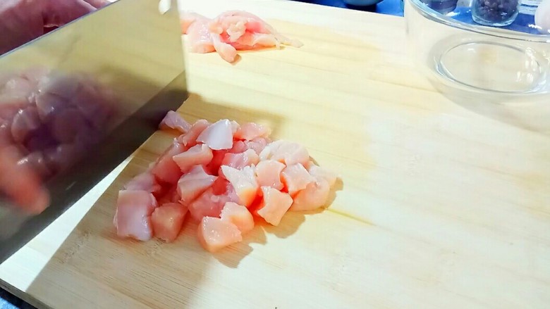 迷香罗勒鸡米花,改刀，切成一厘米见方的肉块，切好后，放进搅拌碗里。