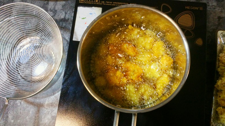 迷香罗勒鸡米花,用炸货长筷子把鸡肉一粒粒夹进锅里。
