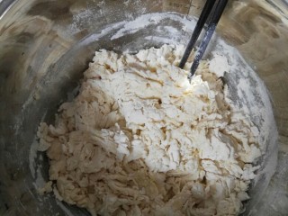 玉米开花馒头,十分钟后加入面粉，用筷子一个方向搅拌面粉，使面粉和水均匀融合，最后成絮状即可。