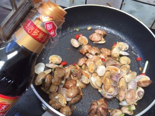 香辣爆炒花蛤,淋入少许生抽，均匀翻炒花蛤1-2分钟，加入鸡精，便可出锅了。