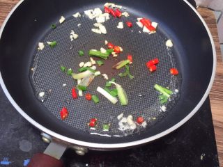 香辣爆炒花蛤,锅中热油，丢入葱段 、小米椒 蒜粒爆香。