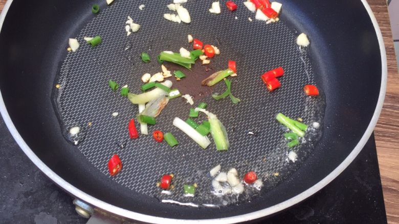 香辣爆炒花蛤,锅中热油，丢入葱段 、小米椒 蒜粒爆香。