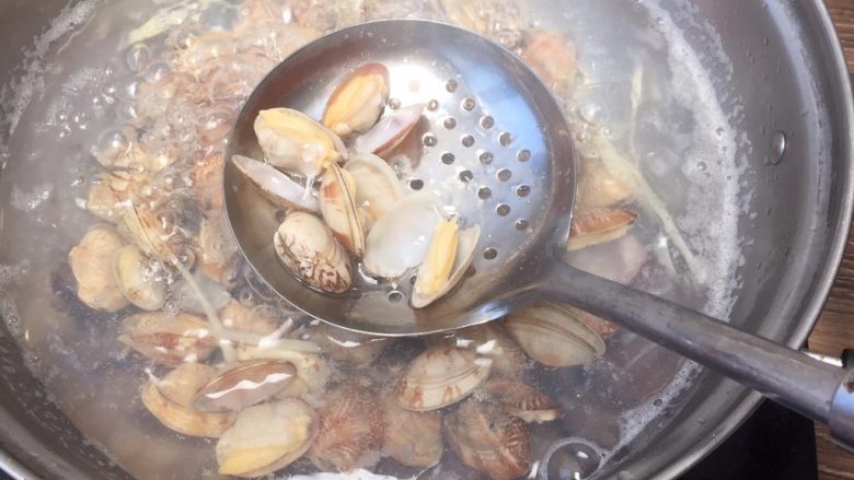 香辣爆炒花蛤,锅中烧沸水 丢入姜丝、花蛤焯水，直至花蛤开口 。捞出花蛤 清水冲洗1-2遍