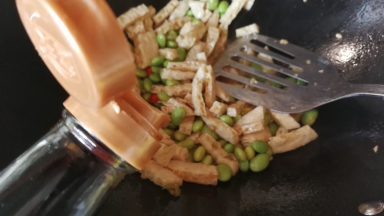 绿色美食+鸡毛菜脆皮豆腐炒毛豆,放入一茶勺盐炒均匀后倒入少量生抽炒均