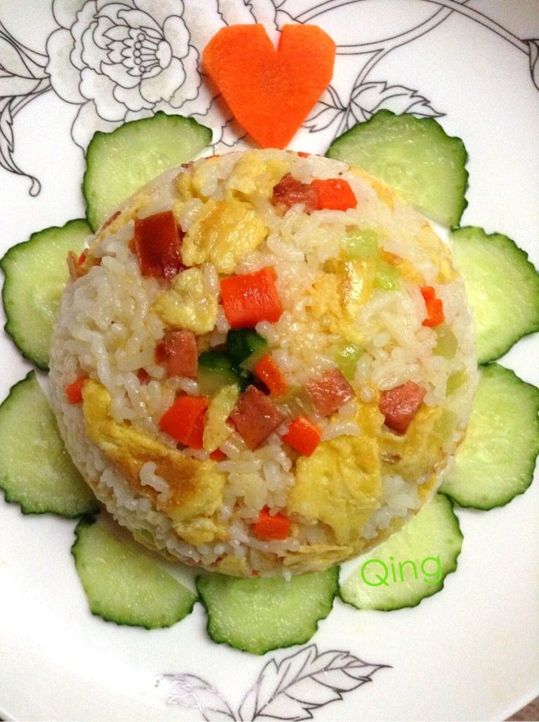 缤纷蛋炒饭,将碗倒扣在盘子上用黄瓜和萝卜加以装饰。