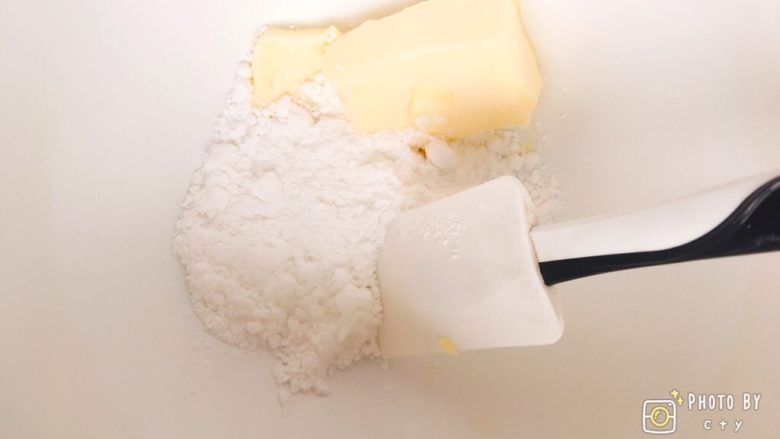 松软香甜的橙皮丁磅蛋糕,黄油中加入糖粉，用刮刀翻拌均匀。