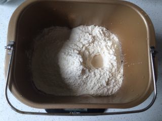 香葱培根芝士面包（咸香味）,面包机中放入水、全蛋、奶粉、细砂糖、盐、低筋面粉、高筋面粉和耐高糖酵母。（材料按照顺序放，避免酵母和糖盐先接触从使酵母失去活性。夏季液体材料需要放入冰箱冷藏2小时再使用）