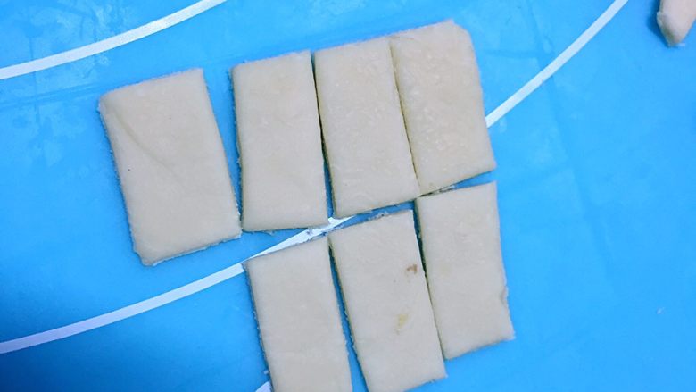 南瓜味蜜豆草帽馒头,白色的面团擀成薄片，切成1＊2厘米的长方形薄片。