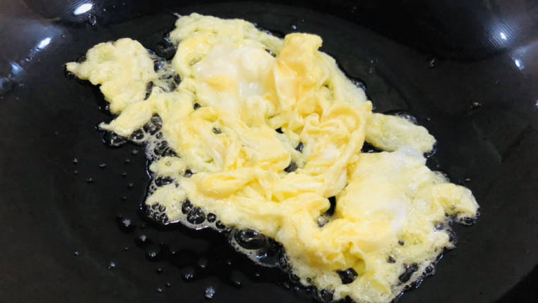 玉米虾仁蛋炒饭,另起锅，锅中倒入少许食用油，倒入搅打好的鸡蛋快速炒成块状后先盛出备用。