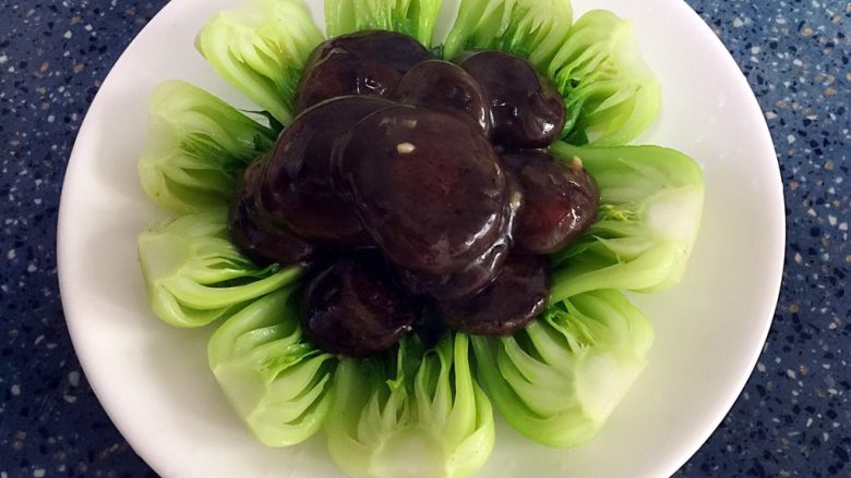 蚝油香菇菜心,把煮好的香菇摆放在备用的青菜上。
