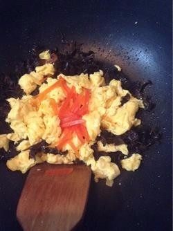 木耳炒鸡蛋,6.接着放入炒好的鸡蛋和红椒，因为鸡蛋液里已经加过盐了，这里也就少放点盐，翻拌均匀。