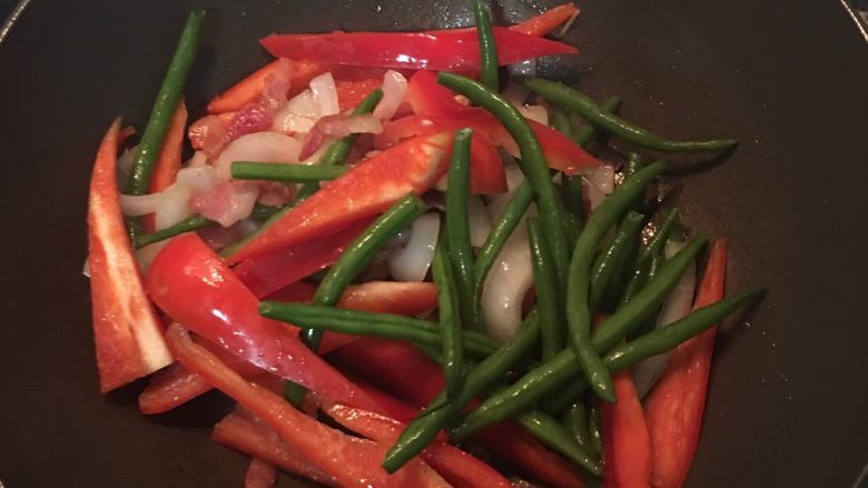 甜椒燉雞腿,再放入紅椒及青豆並加入調味料拌炒。