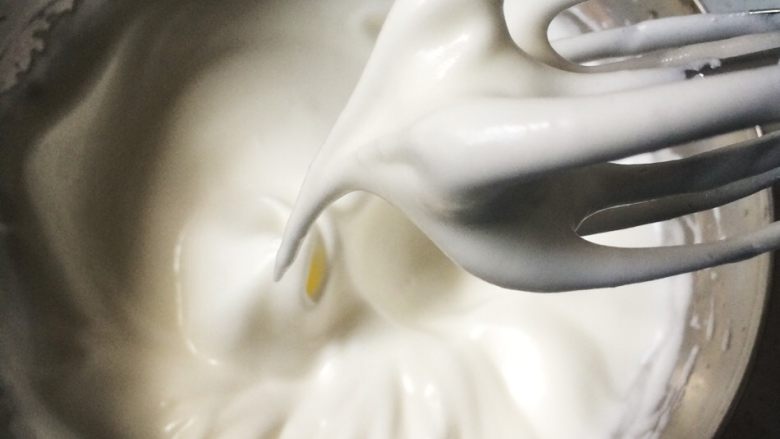 酸奶天使蛋糕,加入二分之一细砂糖，高速打发3-5分钟，继续加入剩余的细砂糖，将蛋白霜打到湿性发泡，六七分。提起打蛋器，蛋白霜半流动状态，打蛋器头上的蛋白霜拉起很长弯弯的尖勾。