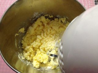 蔓越莓磅蛋糕,软化的黄油用电动打蛋器打至乳霜状后加入一半的糖粉，继续用电动打蛋器搅打