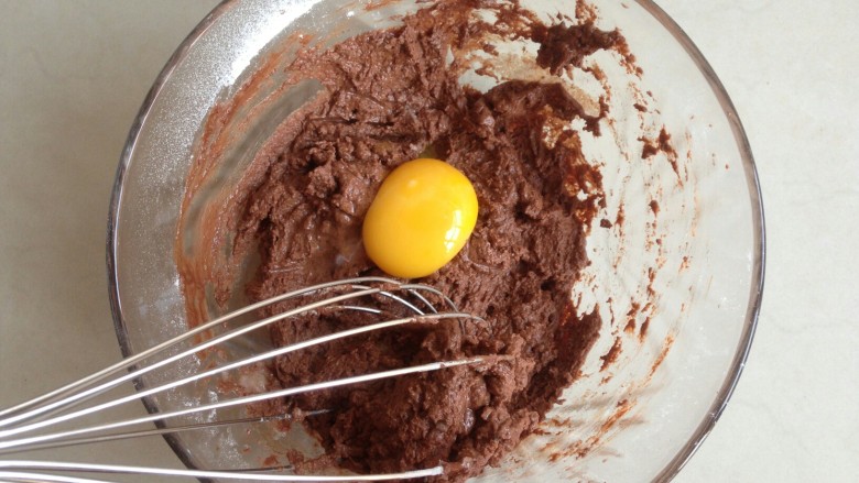 淋面可可蛋糕,分三次加入蛋黄，每加入一个，拌均匀后再加入下一个。