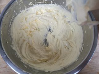 巧克力淡奶油曲奇,电动打蛋器不开，先搅拌一下防止糖粉飞溅，搅拌均匀后打发至颜色发白体积膨大。
如图。打发过程中若黄油过热，立刻离开温水取出，继续打发。

